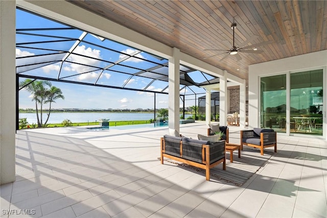 view of patio featuring outdoor lounge area, a lanai, a ceiling fan, and a water view