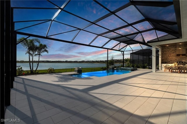 view of swimming pool with glass enclosure, a water view, a pool with connected hot tub, and a patio area