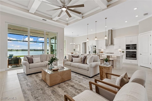 living area featuring visible vents, beamed ceiling, ceiling fan with notable chandelier, light tile patterned flooring, and a towering ceiling