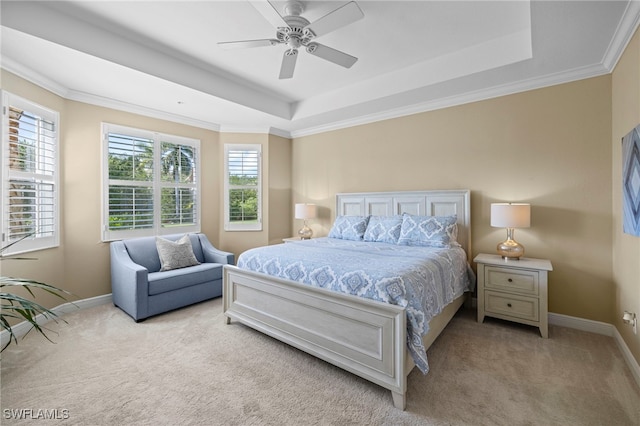 carpeted bedroom with a ceiling fan, baseboards, a raised ceiling, and crown molding