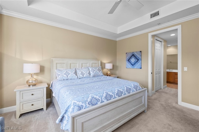 bedroom featuring a tray ceiling, visible vents, and light carpet