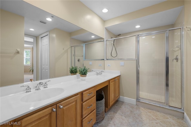 full bathroom with tile patterned flooring, a sink, visible vents, a shower stall, and double vanity