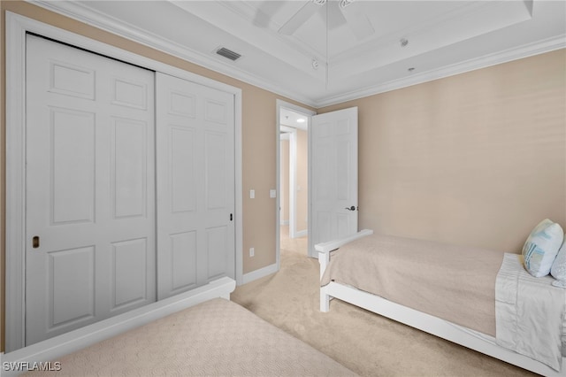 bedroom with baseboards, visible vents, a raised ceiling, carpet, and crown molding