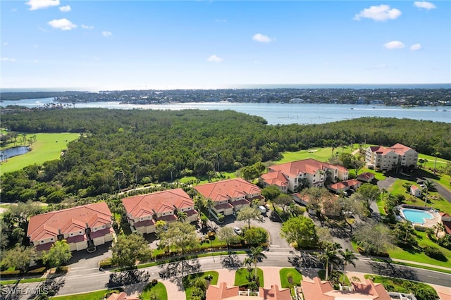 aerial view with a forest view, a water view, and a residential view