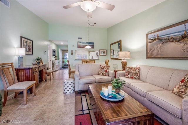 living area featuring light tile patterned floors, visible vents, and a ceiling fan