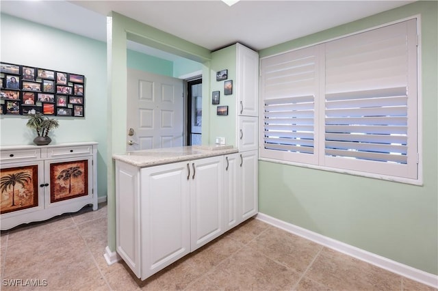 bar featuring baseboards and light tile patterned flooring