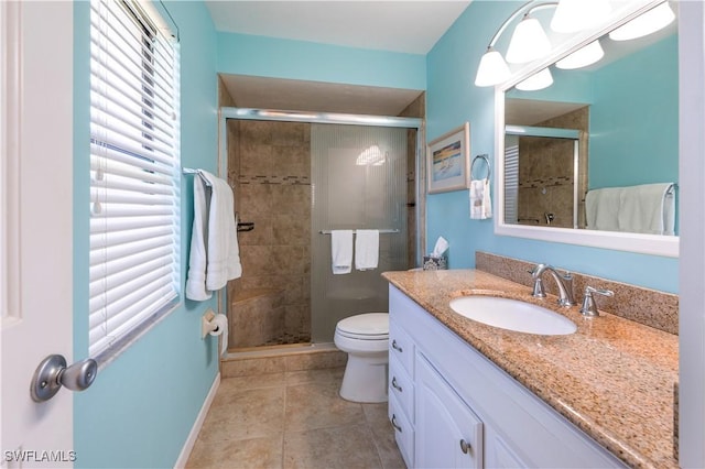 bathroom featuring tile patterned floors, toilet, a stall shower, and vanity