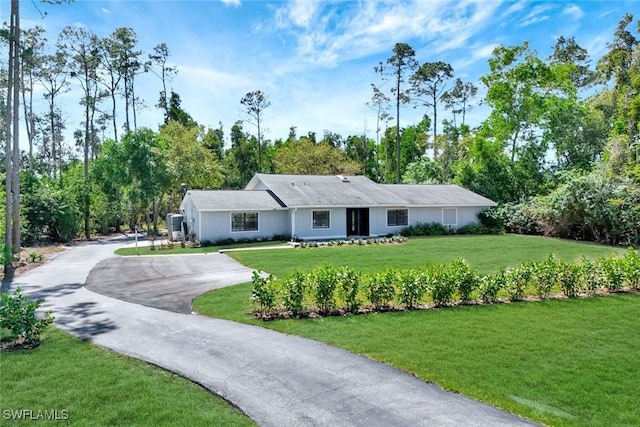 single story home featuring aphalt driveway and a front yard