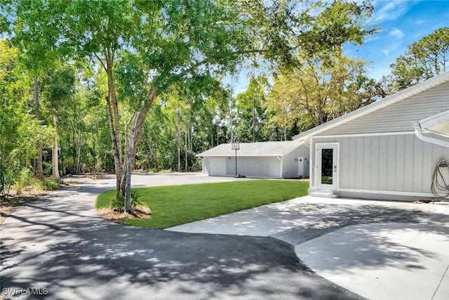 view of yard with a garage and concrete driveway