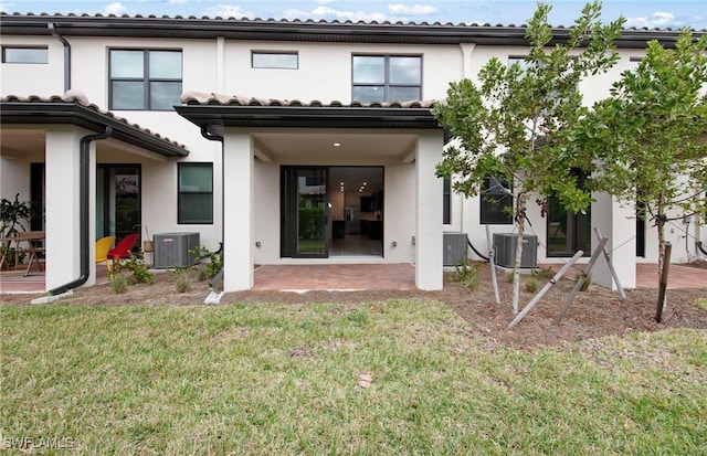 rear view of property with a lawn, a patio area, and cooling unit