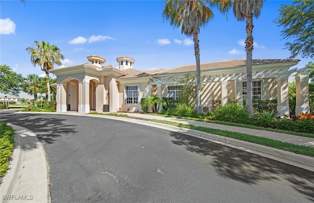 mediterranean / spanish-style home with a tiled roof and stucco siding