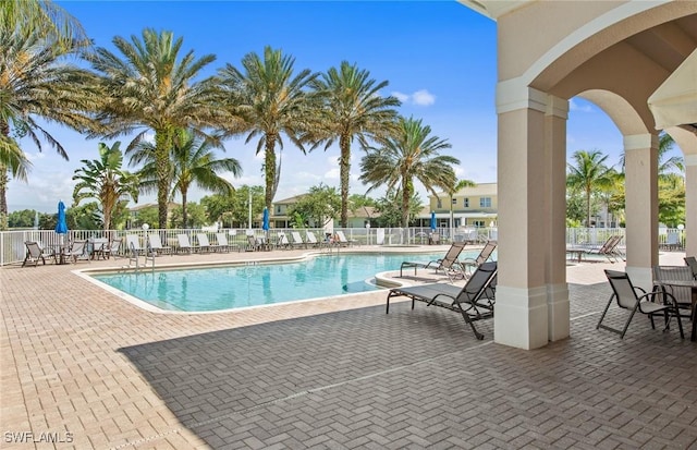 community pool featuring a patio and fence