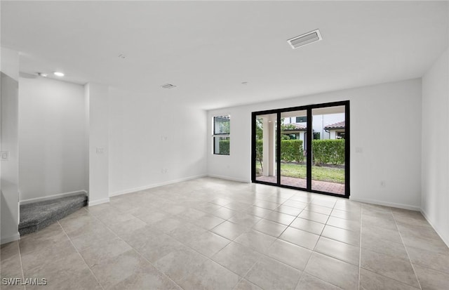 spare room with light tile patterned floors, baseboards, visible vents, stairway, and recessed lighting