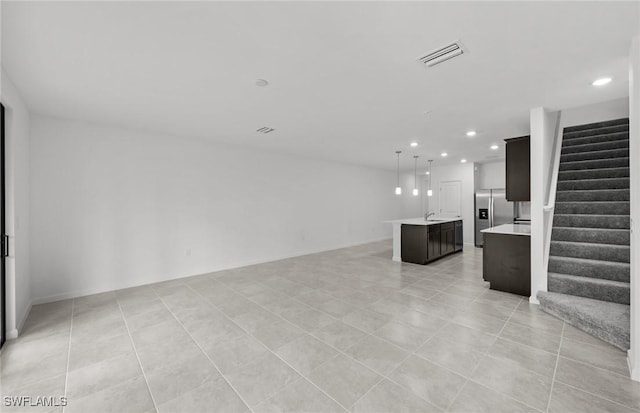 unfurnished living room with recessed lighting, visible vents, light tile patterned flooring, and stairs