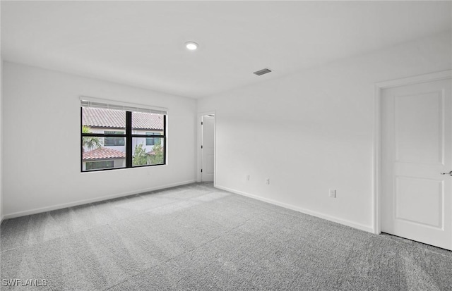 carpeted spare room with baseboards and visible vents