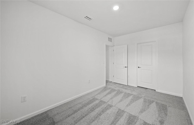 unfurnished bedroom featuring recessed lighting, visible vents, light carpet, and baseboards