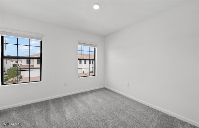 carpeted spare room with baseboards