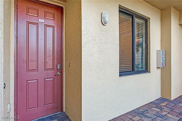 property entrance with stucco siding