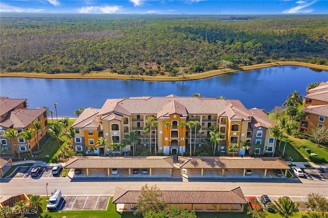 aerial view with a residential view, a water view, and a view of trees