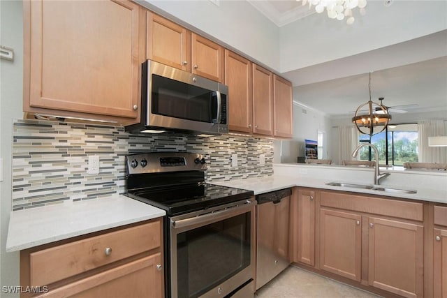 kitchen featuring crown molding, appliances with stainless steel finishes, a sink, and a notable chandelier