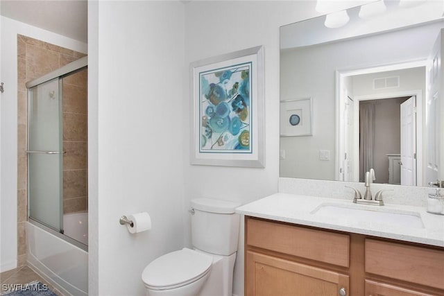 bathroom with visible vents, shower / bath combination with glass door, vanity, and toilet