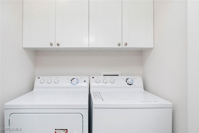 clothes washing area with cabinet space and washing machine and clothes dryer