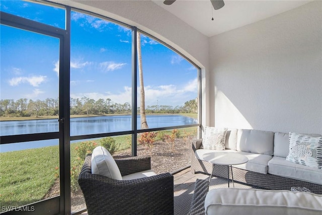 sunroom featuring a water view and a ceiling fan