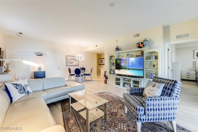 living area featuring light wood finished floors and visible vents