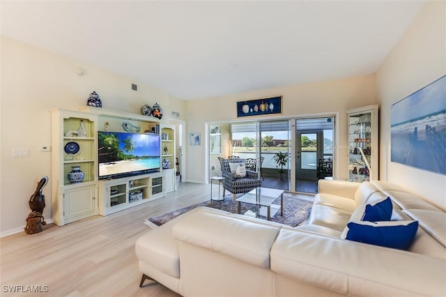 living room featuring visible vents, baseboards, and wood finished floors