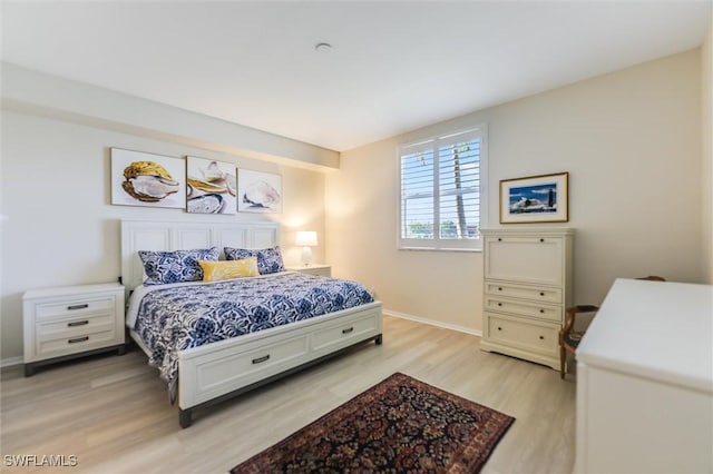 bedroom featuring light wood-style floors and baseboards