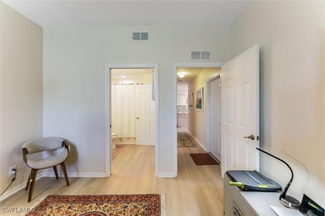 home office featuring light wood-style flooring, visible vents, and baseboards