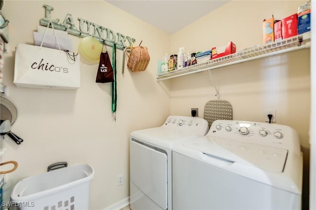 washroom featuring washing machine and dryer, laundry area, and baseboards