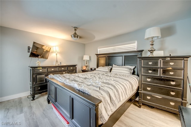 bedroom with light wood-style flooring and baseboards