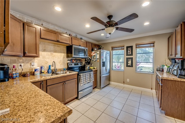 kitchen with stainless steel appliances, brown cabinetry, a sink, and backsplash