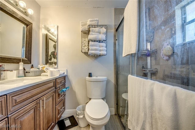 full bath featuring baseboards, a shower stall, toilet, and vanity