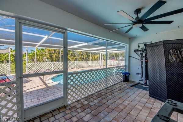 view of pool featuring a fenced in pool, glass enclosure, a patio area, and a ceiling fan