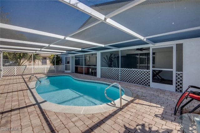 pool featuring glass enclosure and a patio area