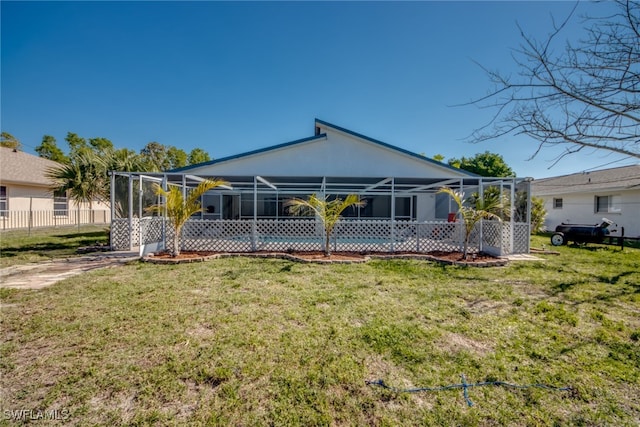 back of property with a yard and a lanai