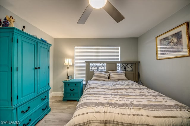 bedroom with a ceiling fan, light wood-style flooring, and baseboards