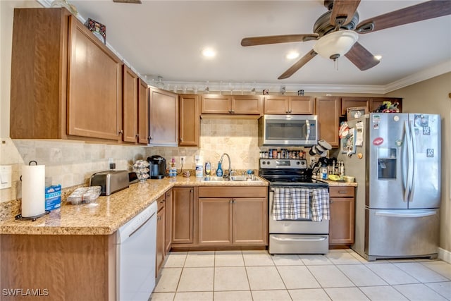 kitchen with crown molding, light tile patterned floors, stainless steel appliances, decorative backsplash, and a sink