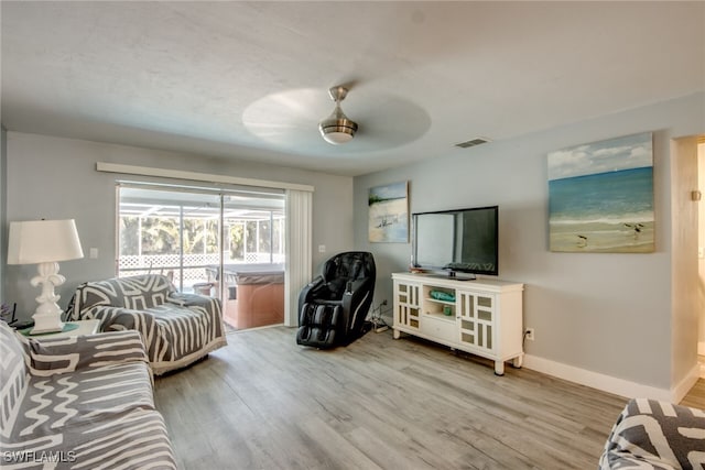 living room with baseboards, ceiling fan, visible vents, and wood finished floors