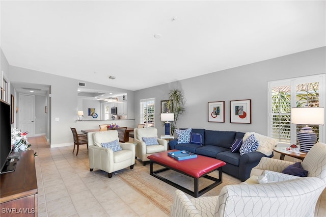 living area with visible vents, baseboards, and light tile patterned flooring