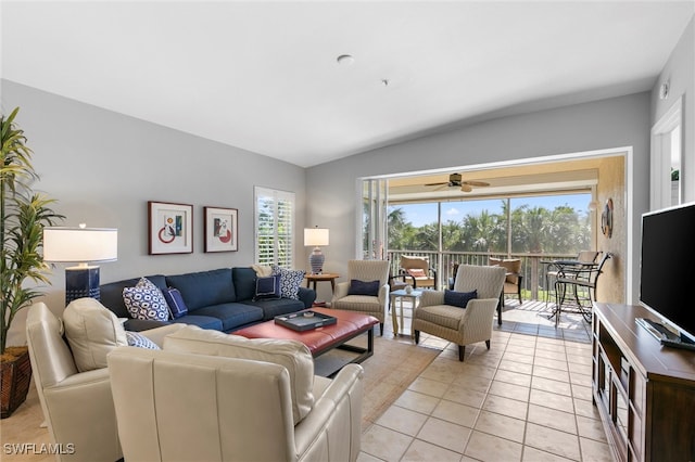 living room with lofted ceiling, light tile patterned floors, and a ceiling fan