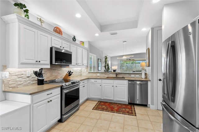 kitchen featuring stainless steel appliances, recessed lighting, tasteful backsplash, white cabinets, and a sink