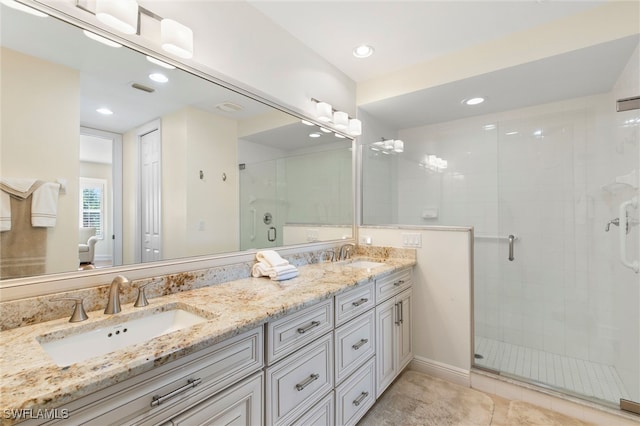 bathroom with double vanity, a stall shower, visible vents, and a sink