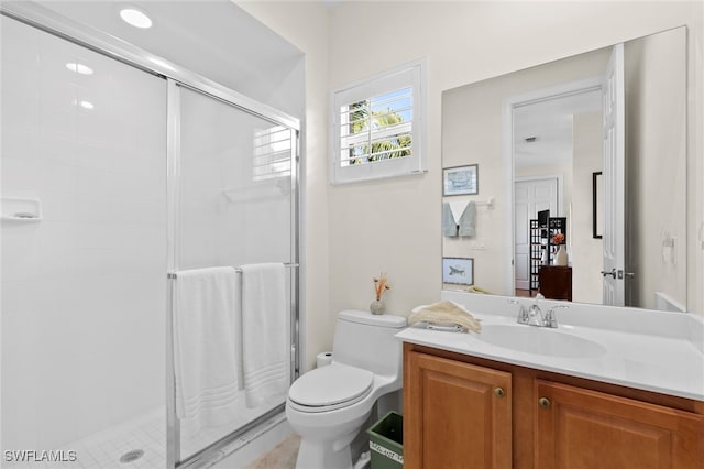 bathroom featuring a shower stall, toilet, and vanity