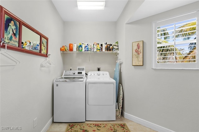 washroom with washing machine and dryer, laundry area, baseboards, and light tile patterned floors