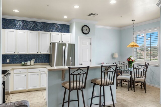 kitchen featuring white cabinetry, light countertops, electric range oven, and freestanding refrigerator