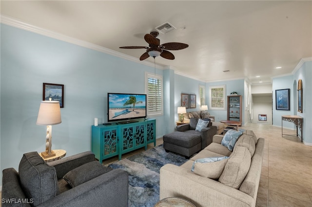 living area with crown molding, light tile patterned floors, visible vents, ceiling fan, and baseboards