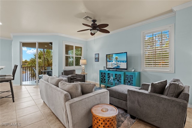 living room with a wealth of natural light, visible vents, crown molding, and light tile patterned flooring